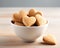 Heart shaped cookies in a white bowl on a wooden table. Shallow dof.