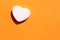 Heart shaped cosmetic soap bar on orange background