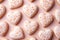 Heart shaped delicious glazed cookies, pink pastel background, top view.