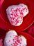 Heart-shaped donuts with tiny red heart sprinkles on red plates