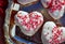 Heart-shaped donuts with tiny red heart sprinkles on silver tray
