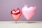 Heart shaped foil balloons adorn pastel pink background, perfect for romantic celebrations