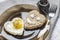 Heart shaped fried egg and bread in a plate, on a set table. Smiley on a piece of bread.