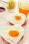 Heart-shaped fried eggs, bread and orange juice