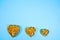 Heart shaped of gold pills on blue paper background