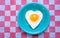 Heart-shaped grilled egg on a teal plate