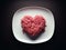 Heart-shaped ground meat on a plate, concept of love for meat