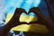 Heart shaped hands on Ukrainian flag with shadows. Priority question. Breaking news. Ukrainian flag, Creative patriotic