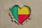 Heart shaped hole torn through paper, showing Benin flag