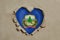 Heart shaped hole torn through paper, showing Vermont flag