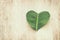 heart shaped leaf over wooden table. ecology and health concept.