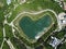 Heart shaped love lake shot. Aerial drone view of peace symbol in natural environment. Overhead natural wonder pond