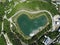 Heart shaped love lake shot. Aerial drone view of peace symbol in natural environment. Overhead natural wonder pond
