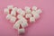 Heart shaped marshmallows on a pink background close up and copy space. Marshmallow heart top view on a pink background