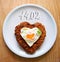 Heart shaped minced steak with fried egg .