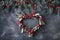 Heart-shaped mistletoe Christmas wreath and festive garland made from fir twigs, frosted berries and trinkets
