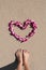 Heart shaped orchid flower garland white sea sand beach with woman feet