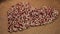 Heart-shaped pile of beans on brown cloth, healthy nutrition, organic food