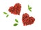 Heart shaped piles of dried goji berries and leaves on white background