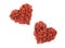 Heart shaped piles of dried goji berries on white background