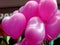 heart shaped pink balloons on strings with blurry background