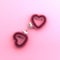 Heart shaped pink handcuffs on pink background. Valentine`s day creative minimal concept