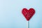Heart-shaped red lollipop on a light blue background - perfect for a cool wallpaper