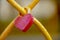 Heart-shaped red padlock. Metal heart on the fence.