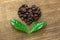 Heart shaped roasted coffee beans and leaves