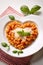 Heart shaped spaghetti with tomato sauce and parmesan cheeses on white plate. AI Generated