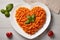 Heart shaped spaghetti with tomato sauce and parmesan cheeses on white plate. AI Generated