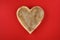 Heart shaped wooden bowl on a red background, rustic happy Valentineâ€™s Day