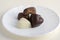 Heart shapped chocolate sweets, brown and white color, white plate