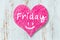 Heart sign with word Friday on wooden background