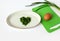 Heart of sliced green onions on a white plate, green cutting board, green onions on a white background - the concept of vitamin