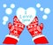 A heart of snow lies in mittens on a blue background.