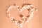 Heart symbol made of Peach Fuzz hydrangea flower petals on a background