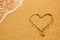 Heart symbol on the sand. Summer holiday concept. Romantic love background. Valentin Day theme. Top view. Heart drawn in sea beach