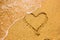 Heart symbol on the sand. Summer holiday concept. Romantic love background. Valentin Day theme. Top view. Heart drawn in sea beach