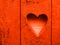 Heart on wooden rustic wall. Heart sign, hole. Lush lava colour. Lush lava color heart pattern