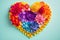 A heart wrapped in colorful flower petals, papercraft, on blue turquise background, Generative AI