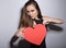 Heartbreaker. Temptress. Seductive woman. Portrait of amazing young fashion woman posing at studio with red heart. Love. Valentine
