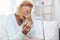 Heartbroken elderly woman holding a wedding ring