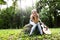 Heartbroken woman in nature with guitar