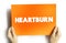 Heartburn is a burning feeling in the chest caused by stomach acid travelling up towards the throat, text concept on card