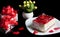 Hearts  gift boxes  flowers and cake with red berries on white plate Isolated on black background. Holiday food Valentines day