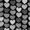 Hearts hand drawn seamless vector pattern. White heart shapes on black background. Monochrome design. Textured hearts backdrop.