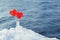 Hearts lollipops in the snow on the background of sea waves. Romantic date, Declaration of love, Valentine`s day