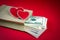 Hearts paper bag with money on a red background