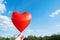 Heartshaped balloon soaring in blue sky